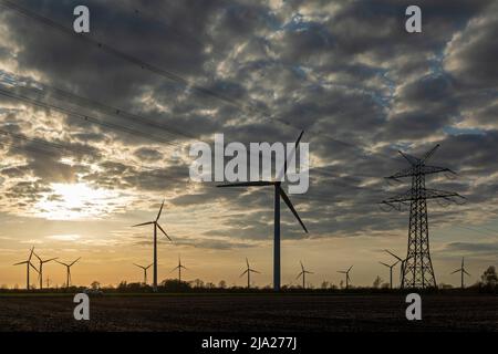 Windturbinen und Hochspannungsmast, Sonnenuntergang, bei Schuby, Schleswig-Holstein, Deutschland Stockfoto