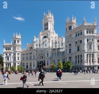 Fußgänger und Touristen vor dem Palacio de Cibeles, einem Gebäude von kulturellem Interesse, das von Antonio Palacios & Joaquín Otamendi entworfen und in eröffnet wurde Stockfoto