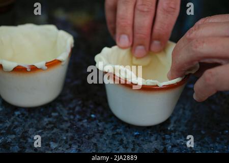 Schwäbische Küche, Mürbeteigkörbe mit Schwarzwälder Schinken zubereiten, Teig in Pfitzauf-Formen geben, Souffle-Formen, aus dem Ofen, salzig Stockfoto