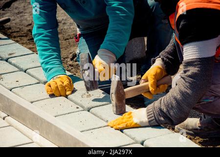 Pflastersteinanlage, Pflaster legen Granitsteinpflaster mit industriellen Pflastersteinen Stockfoto