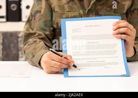 Nahaufnahme der Hände eines Militärs, die den Unterschriftenraum in der Akademie zeigen und zeigen Stockfoto