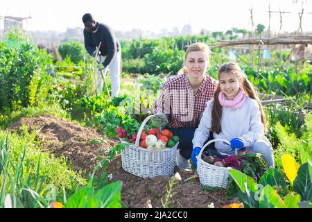 Eine Farmerin und ihre Tochter im Teenageralter halten einen Weidenkorb in der Hand Stockfoto