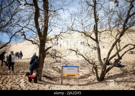Foto von Touristen auf der Dune du Pilat vor einem Schild, das den Eingang zum Ort anzeigt. Die Düne von Pilat, auch Grande Dune du Pilat genannt, ist Th Stockfoto