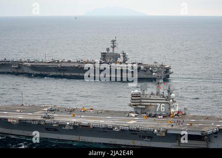 220520-N-DW158-2247 PAZIFISCHER OZEAN (20. Mai 2022) der einzige vorwärts eingesetzte Flugzeugträger der US-Marine, USS Ronald Reagan (CVN 76), dampft während einer vertikalen Auffüllung neben USS Abraham Lincoln (CVN 72). Ronald Reagan, das Flaggschiff der Carrier Strike Group 5, stellt eine kampfbereite Kraft zur Verfügung, die die Vereinigten Staaten schützt und verteidigt und Allianzen, Partnerschaften und kollektive maritime Interessen in der Indo-Pazifik-Region unterstützt. (USA Navy Foto von Mass Communication Specialist 3. Class Grey Gibson) Stockfoto