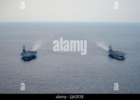 220520-N-DW158-2276 PAZIFISCHER OZEAN (20. Mai 2022) der einzige vorwärts eingesetzte Flugzeugträger der US-Marine, USS Ronald Reagan (CVN 76), dampft während einer vertikalen Auffüllung neben USS Abraham Lincoln (CVN 72). Ronald Reagan, das Flaggschiff der Carrier Strike Group 5, stellt eine kampfbereite Kraft zur Verfügung, die die Vereinigten Staaten schützt und verteidigt und Allianzen, Partnerschaften und kollektive maritime Interessen in der Indo-Pazifik-Region unterstützt. (USA Navy Foto von Mass Communication Specialist 3. Class Grey Gibson) Stockfoto