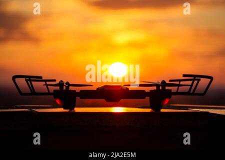 Drohnendrohne auf einem Sonnenuntergangshintergrund steht auf einem Tisch Stockfoto