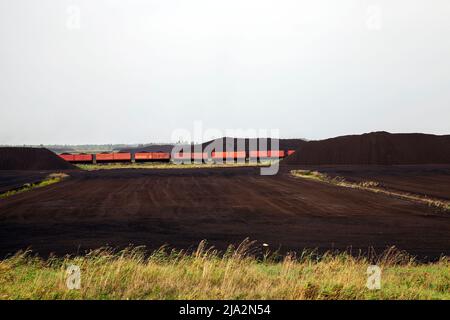 Industriegebiet, in dem schwarzer Torf abgebaut wird, Landschaft in der Natur auf dem Gebiet der Torfgewinnung Stockfoto