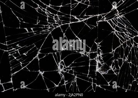 Altes schmutziges Glas mit vielen Rissen, altes zerbrochenes Glas auf schwarzem Hintergrund Stockfoto