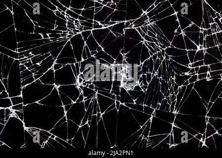 Altes schmutziges Glas mit vielen Rissen, altes zerbrochenes Glas auf schwarzem Hintergrund Stockfoto