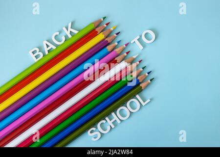 Bunte Neonstifte auf hellblauem Hintergrund. Zurück zum Schulkonzept Stockfoto