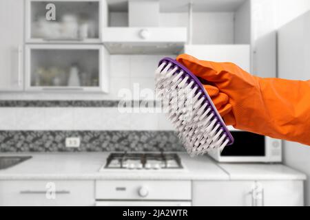 Frauenhand in Schutzhandschuh mit Pinsel. Stockfoto