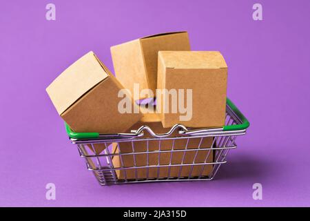 Verschiedene Boxen in einem Lebensmittelkorb auf farbigem Hintergrund, Handels- und Logistikkonzept Stockfoto