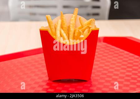 Pommes frites in roter Schachtel auf einem Tablett Stockfoto