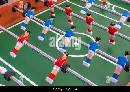 Tischfußballspiel, Fußballtisch mit roten und blauen Spielern. Stockfoto