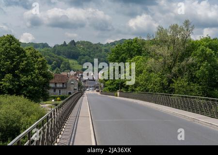 Beaulieu-sur-Dordogne, Frankreich - 13. Mai 2022: Brücke über den Fluss Dordogne in das historische Dorf Beaulieu-sur-Dordogne Stockfoto