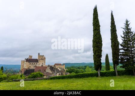 Beynac-et-Cazenac, Frankreich - 12. Mai 2022: Blick auf das Schloss Beynac im Dordogne-Tal unter einem wolkenbedeckten, ausdrucksstarken Himmel Stockfoto