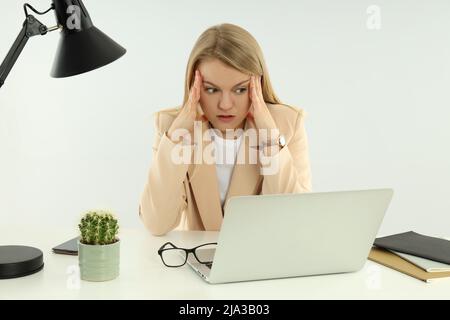 Junge, müde Geschäftsfrau, die am Arbeitsplatz sitzt Stockfoto