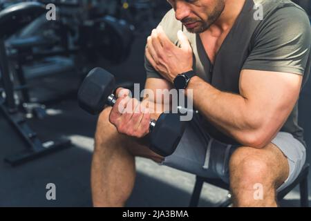 An seinen Armen arbeiten. Kurzer Schuss eines muskulösen jungen Mannes, der im Fitnessstudio trainieren soll. Hochwertige Fotos Stockfoto