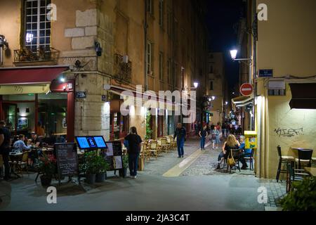 Lyon, Frankreich - 10. Mai 2022 : Touristen, die in Restaurants im Freien essen und andere, die nachts durch die Altstadt von Lyon fahren Stockfoto