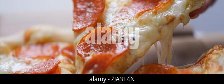 Ein Mann nimmt eine große Scheibe heiße Neopoletan-Pizza Stockfoto