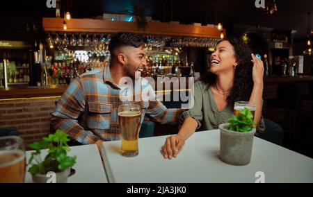 Diverse Freunde, die sich lachend für Getränke ausgelacht haben Stockfoto