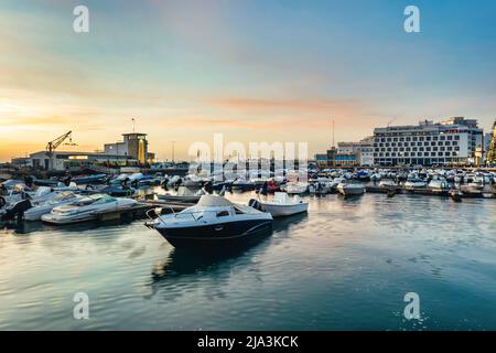 FARO, PORTUGAL - 2.. JANUAR 2022: Blick auf die Docks der Stadt Faro und das Eva Hotel bei Sonnenuntergang in der Algarve. Stockfoto