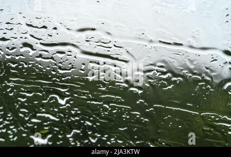 Nasser Regen fällt auf die Fenster Stockfoto