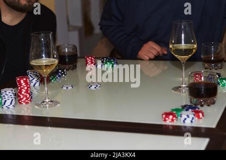 Spieler im Pokerspiel, Würfel, Karten und Glas Champagner und Whiskey. Ehrliche Momente. Poker Hintergrund Lifestyle Fotografie. Genießen Sie den Moment, digitale Entgiftung mit Freunden Stockfoto