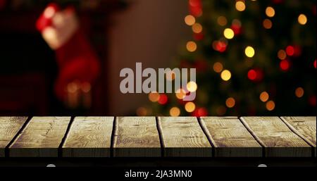 Hölzerner Vordergrund mit Weihnachtshintergrund von Baum und Strumpf Stockfoto