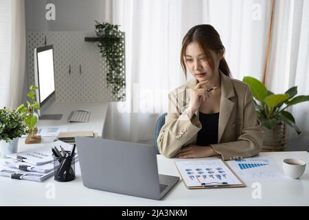 Konzentrierte Geschäftsfrau prüft Finanzdaten auf Computer-Laptop. Stockfoto