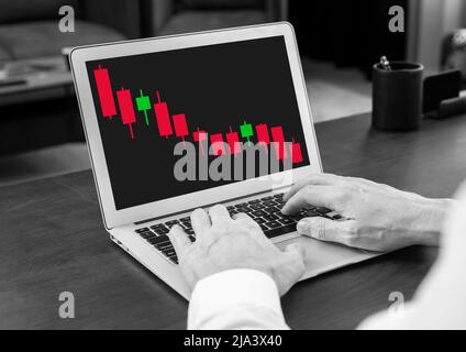 Mann, der am Laptop mit einem abnehmenden Candlestick-Diagramm arbeitet. Abwärtsbewegung des Produktpreises. Krise, Aktienmarktanalyse. Investitions-, Finanzkonzept. Trader reicht die Tastatur. Hochwertige Fotos Stockfoto