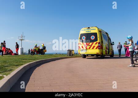 Slowenien, Izola - Juni 5 2021: Ambulanzwagen auf einer belebten Strandstraße voller Menschen im heißen Sommer Stockfoto