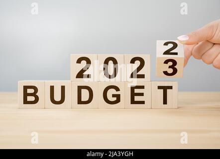 Geschäftskonzept der Planung 2023. Geschäftsmann dreht Holzwürfel und ändert die Wörter BUDGET 2022 auf BUDGET 2023. Businessplan-Konzept für das neue Jahr 2023. Stockfoto