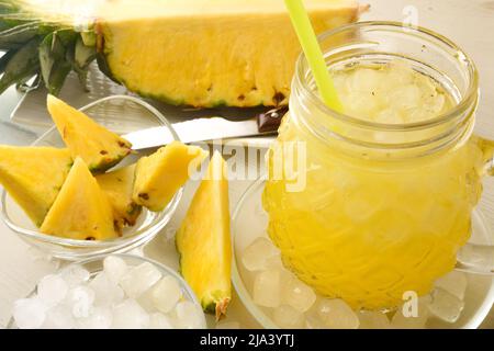 Detail des hausgemachten Ananas-Softdrinks mit viel Eis auf einem Küchentisch. Erhöhte Ansicht. Horizontale Zusammensetzung. Stockfoto