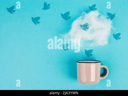 Tasse Kaffee mit einer Dampfwolke, Vögel fliegen zum Himmel, Pastellfarben, Ideenfindung, Denkweise der Freiheit, kreative Geschäftsidee, Optimis Stockfoto