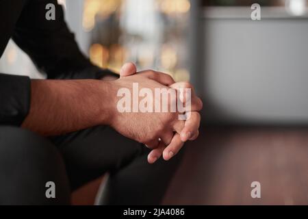 Beschnittenes Bild eines durchdachten Geschäftsmanns, der in einem Coworking-Erholungsgebiet sitzt. Stockfoto