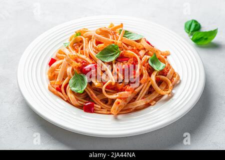 Italienische Linguini-Pasta mit Tomatensauce und frischem Basilikum aus nächster Nähe. Stockfoto