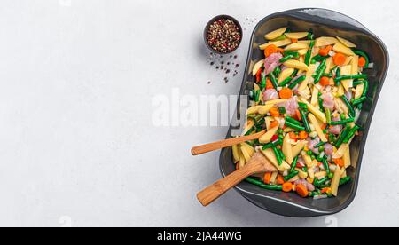 Gemüseeintopf mit Fleisch garen. Rohes Gemüse und putenfleisch in einer Auflaufform. Stockfoto