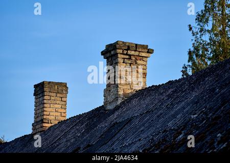 Ein alter Ziegelkamin gegen den blauen Himmel. Stockfoto
