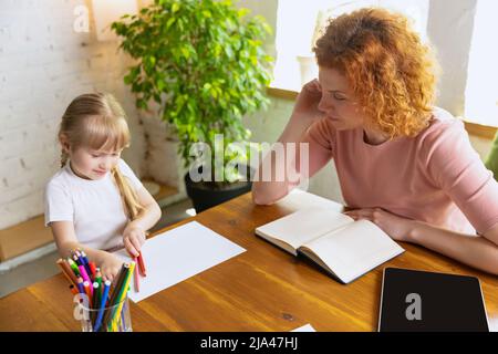 Einzelunterricht im Zentrum der frühen Entwicklung der Kinder. Professionelle Therapeutin kommuniziert mit dem Kind während außerschulischer Aktivitäten. Stockfoto