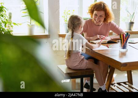 Einzelunterricht im Zentrum der frühen Entwicklung der Kinder. Professionelle Therapeutin kommuniziert mit dem Kind während außerschulischer Aktivitäten. Stockfoto