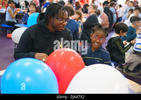 Eltern und Kinder genießen ein großes Jubilee-Mittagessen an der Duncombe Primary School im Norden Londons. Bilddatum: Freitag, 27. Mai 2022. Stockfoto