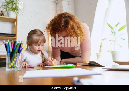 Einzelunterricht im Zentrum der frühen Entwicklung der Kinder. Professionelle Therapeutin kommuniziert mit dem Kind während außerschulischer Aktivitäten. Stockfoto