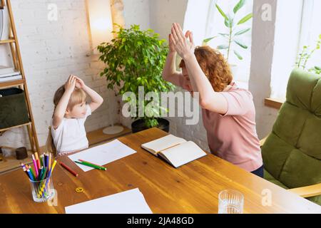 Einzelunterricht im Zentrum der frühen Entwicklung der Kinder. Professionelle Therapeutin kommuniziert mit dem Kind während außerschulischer Aktivitäten. Stockfoto