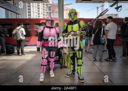 London, Großbritannien. 27.. Mai 2022. Das bunte Boba Fett Star Wars-Charakterpaar wartet auf den DLR-Zug auf dem ersten Tag der MCM Comic-Con Convention im Excel Center im Osten Londons. Kredit: Guy Corbishley/Alamy Live Nachrichten Stockfoto