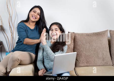 Glückliche Mutter und Tochter feiern den Sieg mit hohen fünf Stockfoto