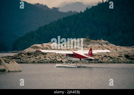 Weiße und rote Dehavilland und Beaver schweben vor dem Start durch einen Schnitt auf einer Insel. Ballet Bay, British Columbia Stockfoto