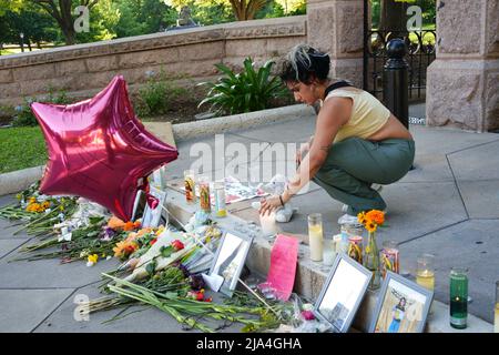 Austin, USA. 26.. Mai 2022. Eine Frau setzt eine Kerze für die Opfer, die bei den Schüssen der Uvalde-Schule vor dem Texas Capitol-Gebäude in Austin, Texas, USA, getötet wurden, 26. Mai 2022. Kredit: Bo Lee/Xinhua/Alamy Live Nachrichten Stockfoto