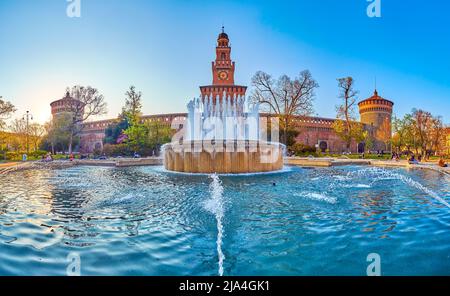 MAILAND, ITALIEN - 5. APRIL 2022: Der Blick auf das Schloss von Sforza durch das Wasser eines großen Brunnens auf der Piazza Castello , am 5. April in Mailand, Italien Stockfoto