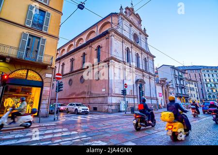 MAILAND, ITALIEN - 5. APRIL 2022: Der Abendverkehr auf der Corso Magenta Straße am monumentalen San Maurizio al Monastero Maggiore, am 5. April in Mailand, Italien Stockfoto